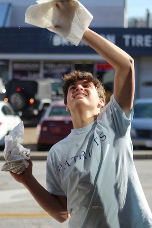 Boy cleaning a window.